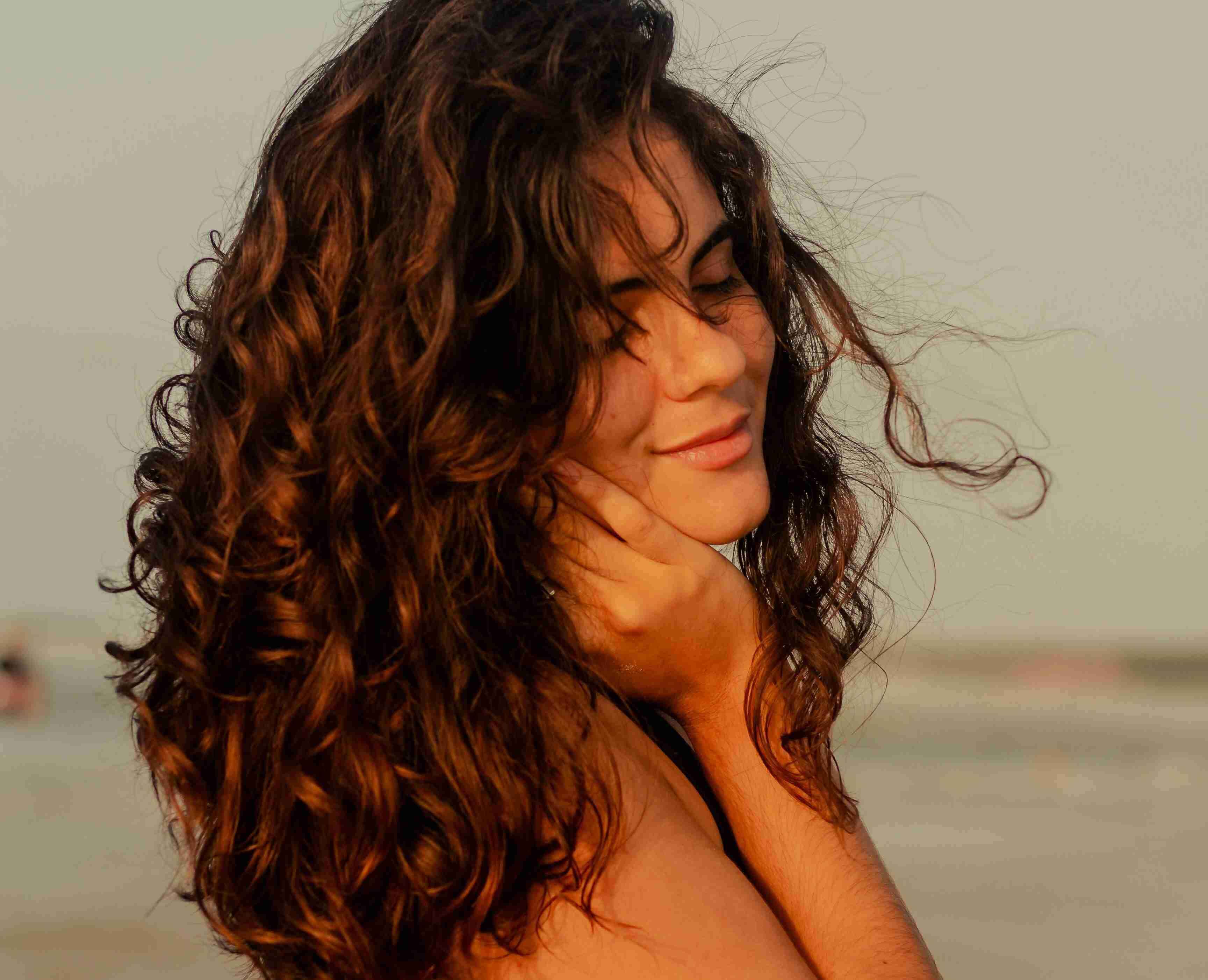 image of a woman with curly hair showing that shea butter can also applied to it